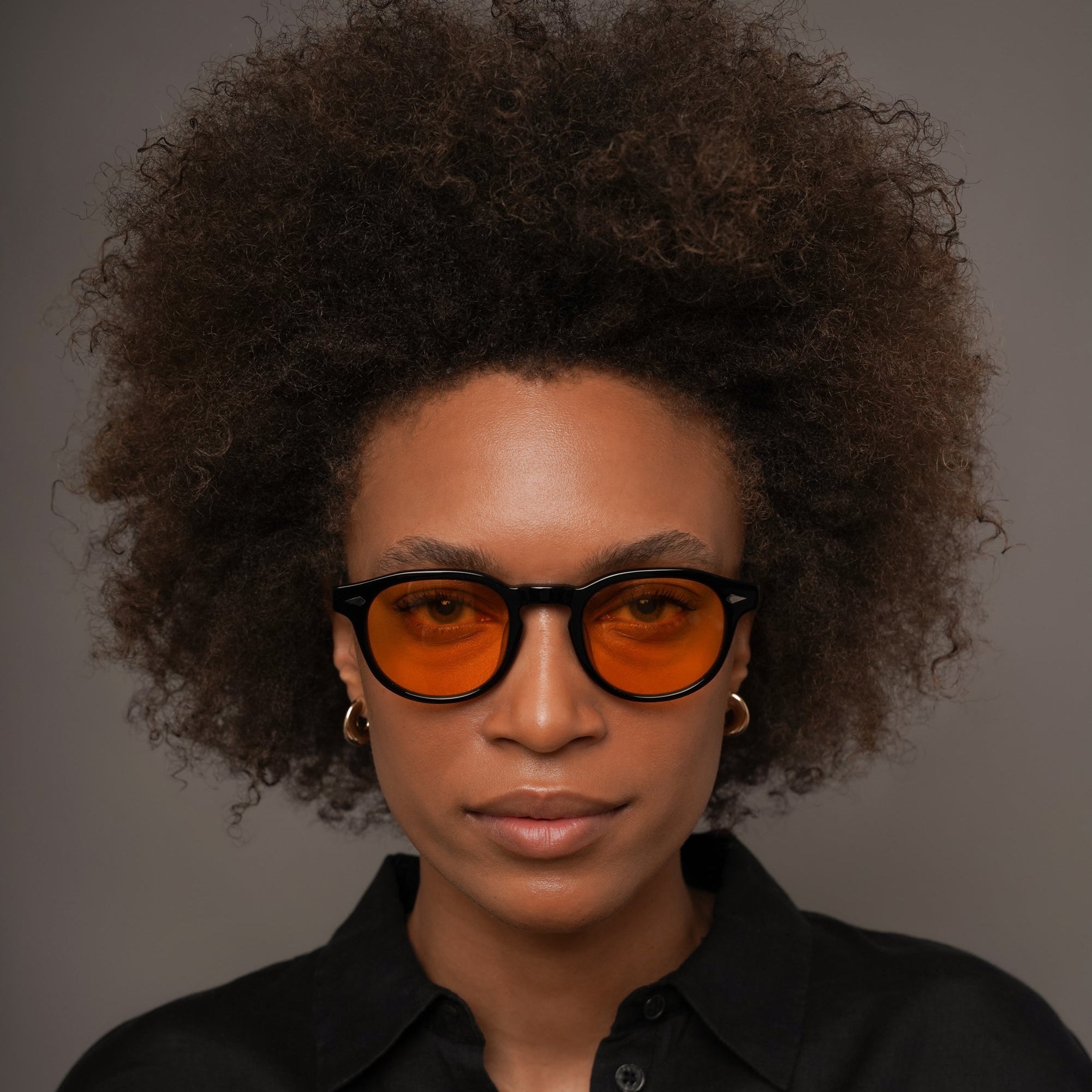 The Basquiat La Vie en Fauve, Mazzucchelli 1849 acetate frame, rounded square shape, black with orange-tinted lenses.