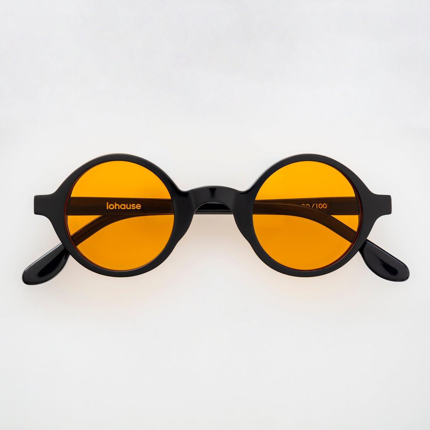 The Winston La Vie en Fauve, Mazzucchelli 1849 acetate frame, round shape, black with orange-tinted lenses.