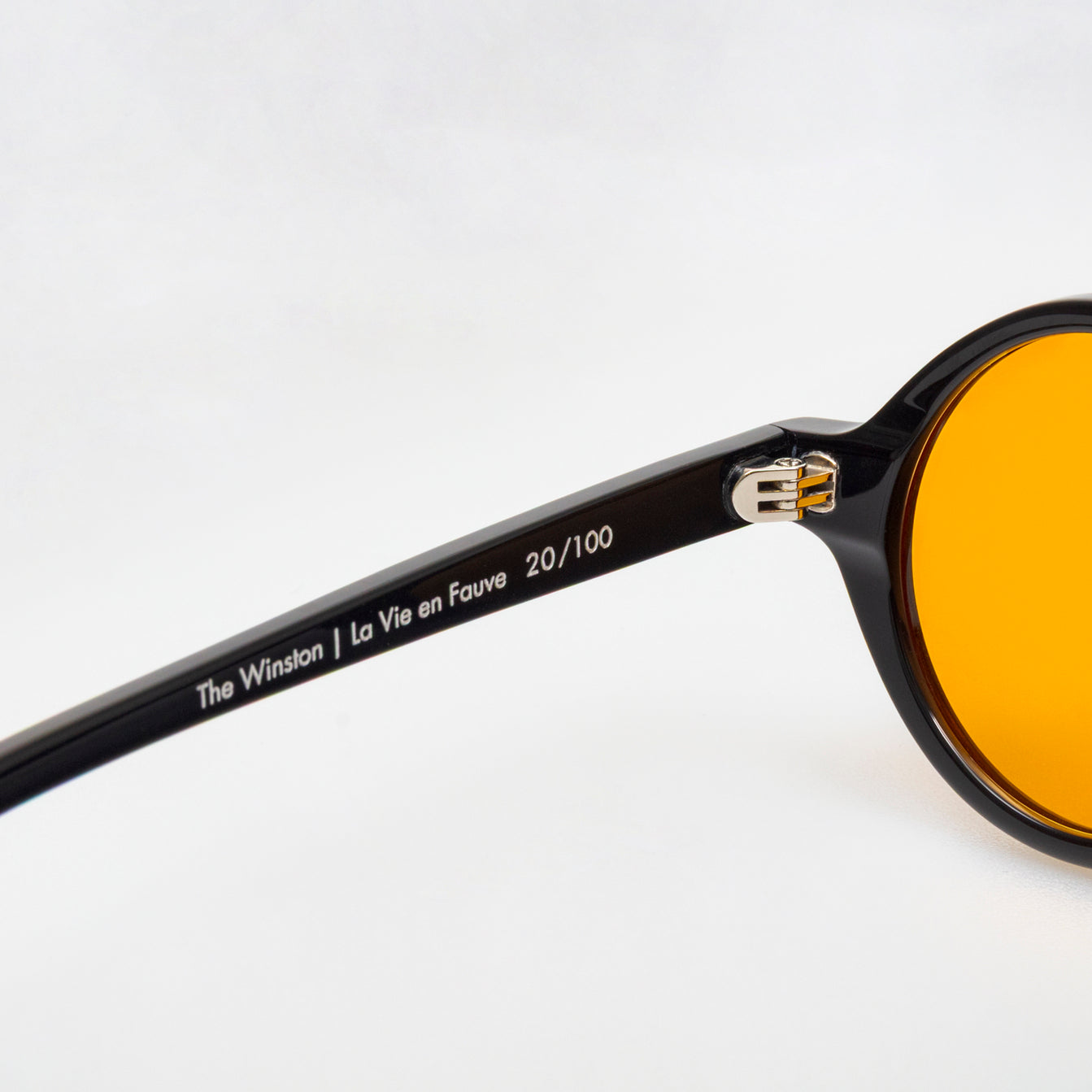 The Winston La Vie en Fauve, Mazzucchelli 1849 acetate frame, round shape, black with orange-tinted lenses.