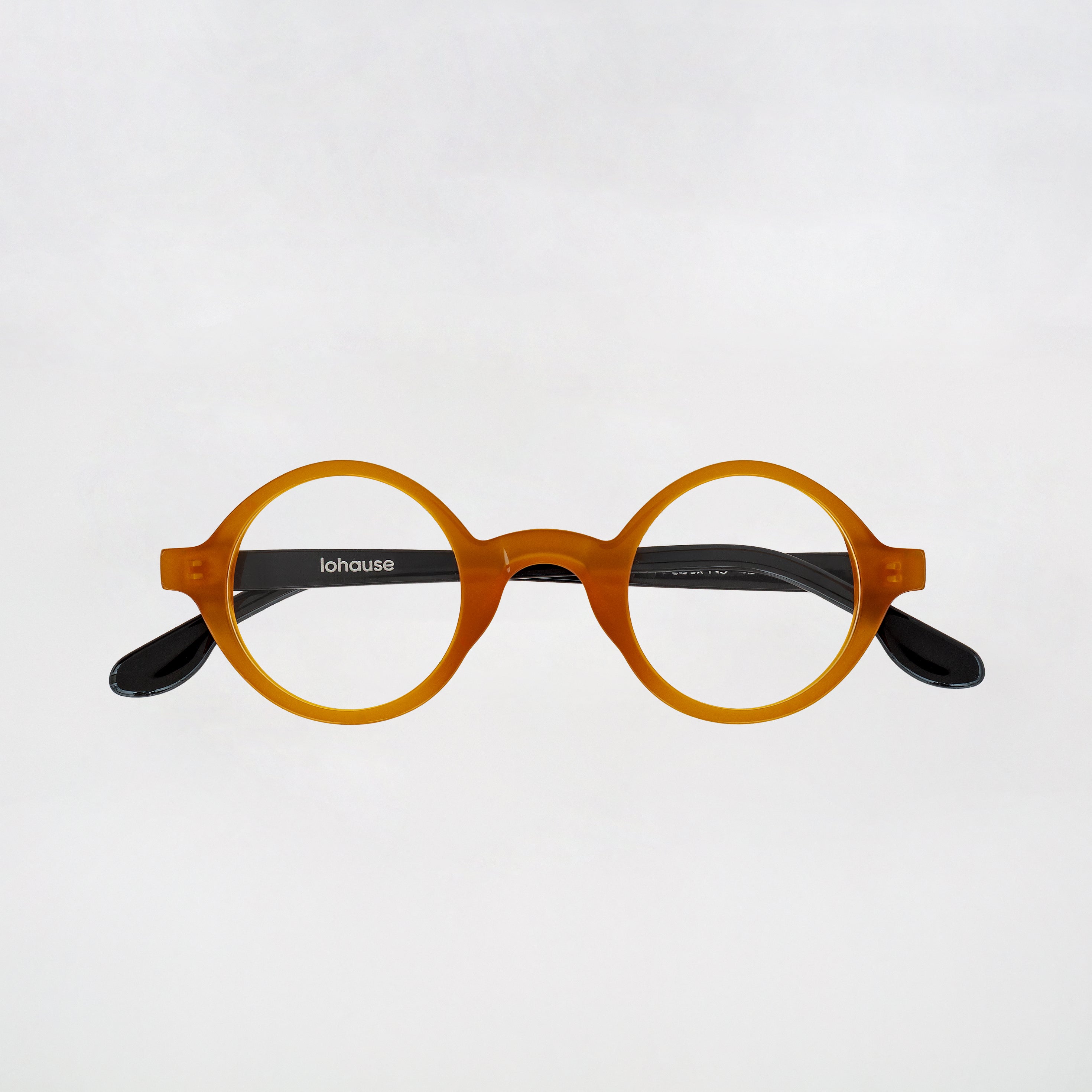Round eyeglasses with brown frame and black arms on a light gray background