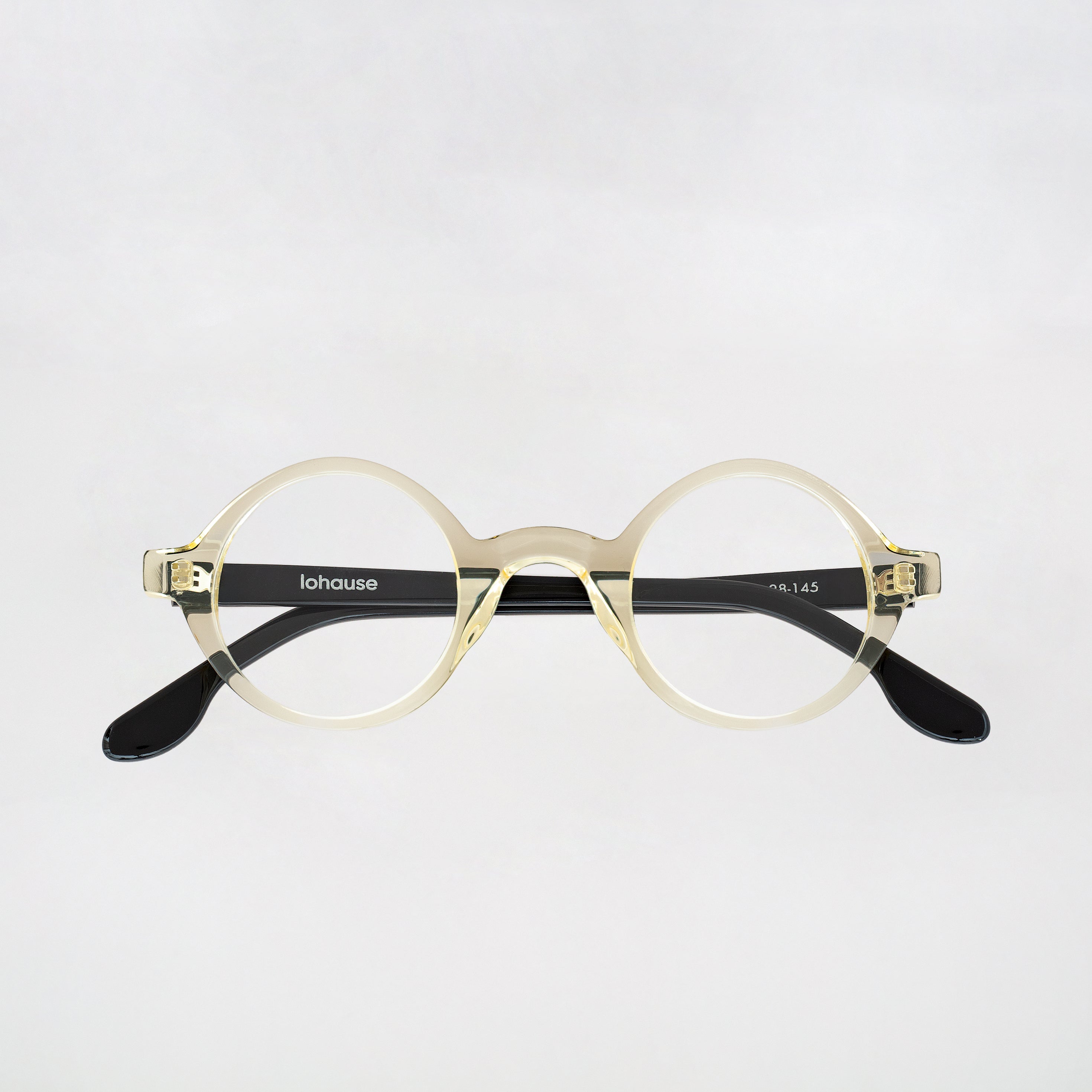 Round eyeglasses with transparent frame and black accents on a light gray background