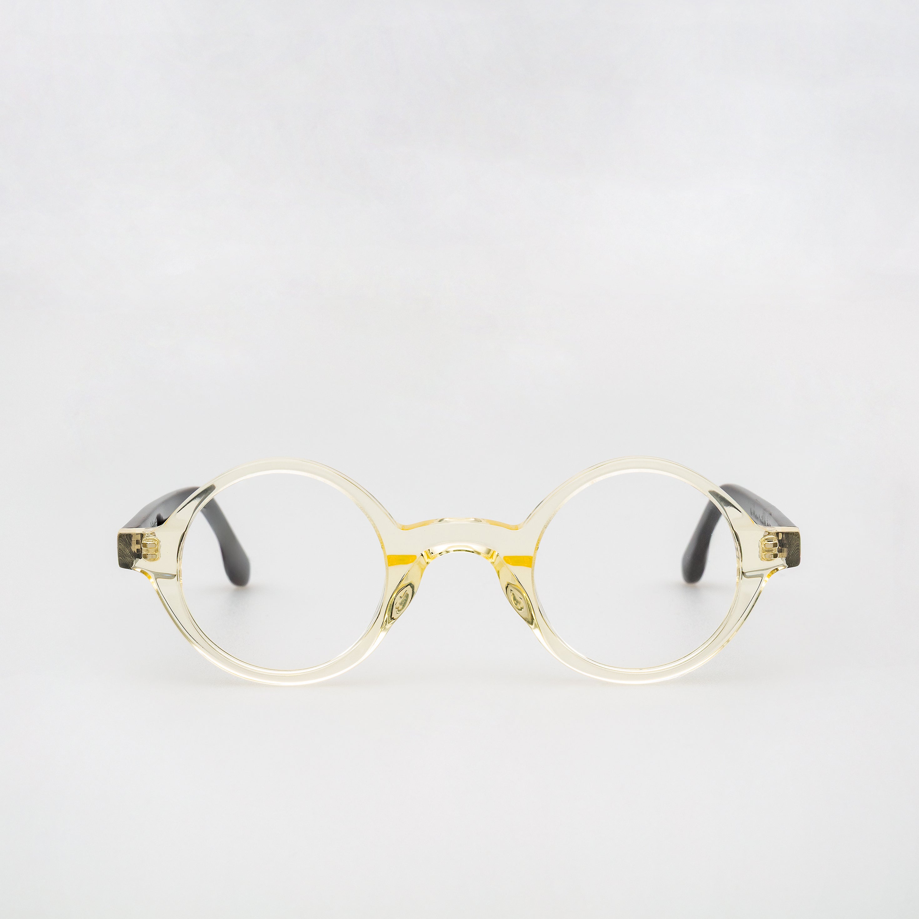 Gold-framed eyeglasses on a light gray background